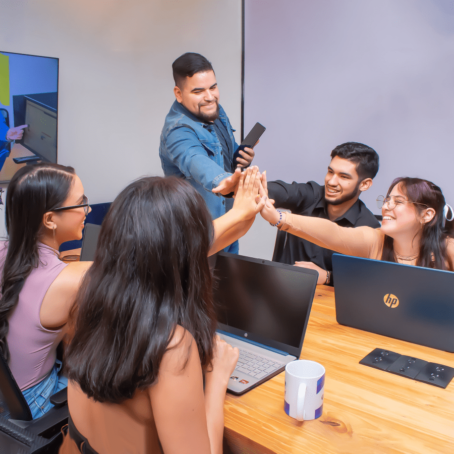 A group of remote workers smiling and interacting with each other at the coworking space.