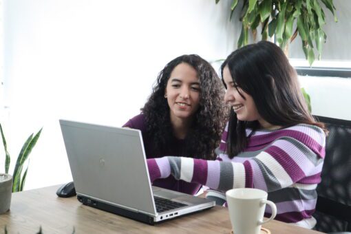 A freelancer pointing to the computer while explaining something to another freelancer